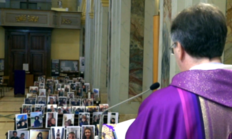 Il parroco dice messa davanti alle foto dei suoi fedeli