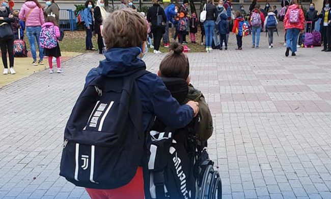 Ogni giorno gli amici spingono la carrozzina di Luca per accompagnarlo a scuola