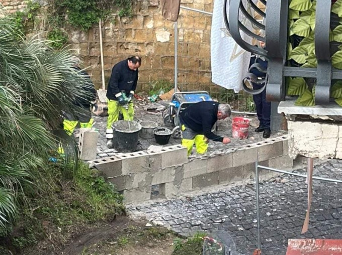 C’è un muro in mezzo alla strada: devono scendere dall’ambulanza e andare a piedi, intanto il paziente muore