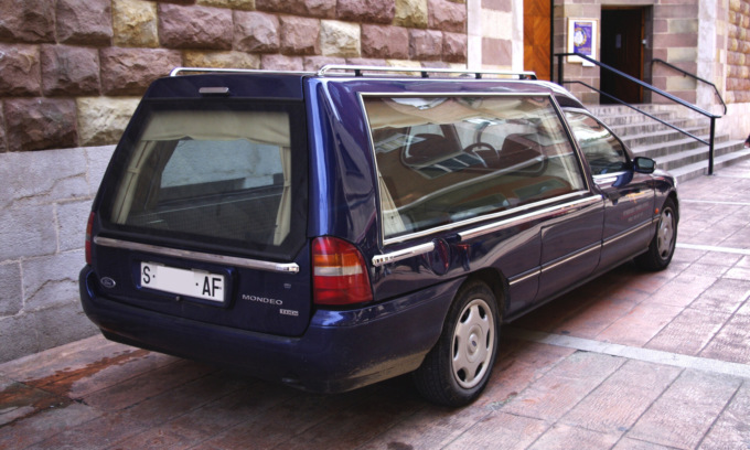Carro funebre parcheggiato davanti alla chiesa durante un funerale multato per divieto di sosta