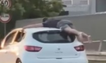 Viaggia in auto aggrappato al tetto: il folle video