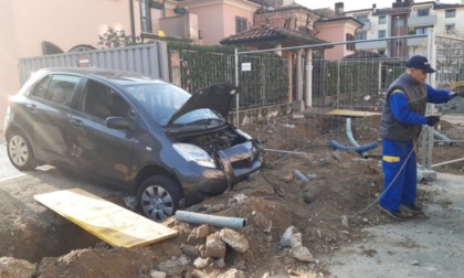 Esce di casa in auto e finisce... nella buca del cantiere