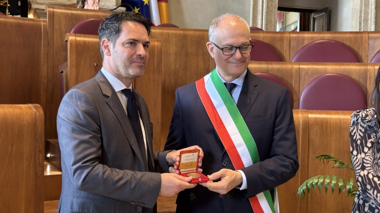 Una studentessa romana firma la medaglia celebrativa del Natale di Roma